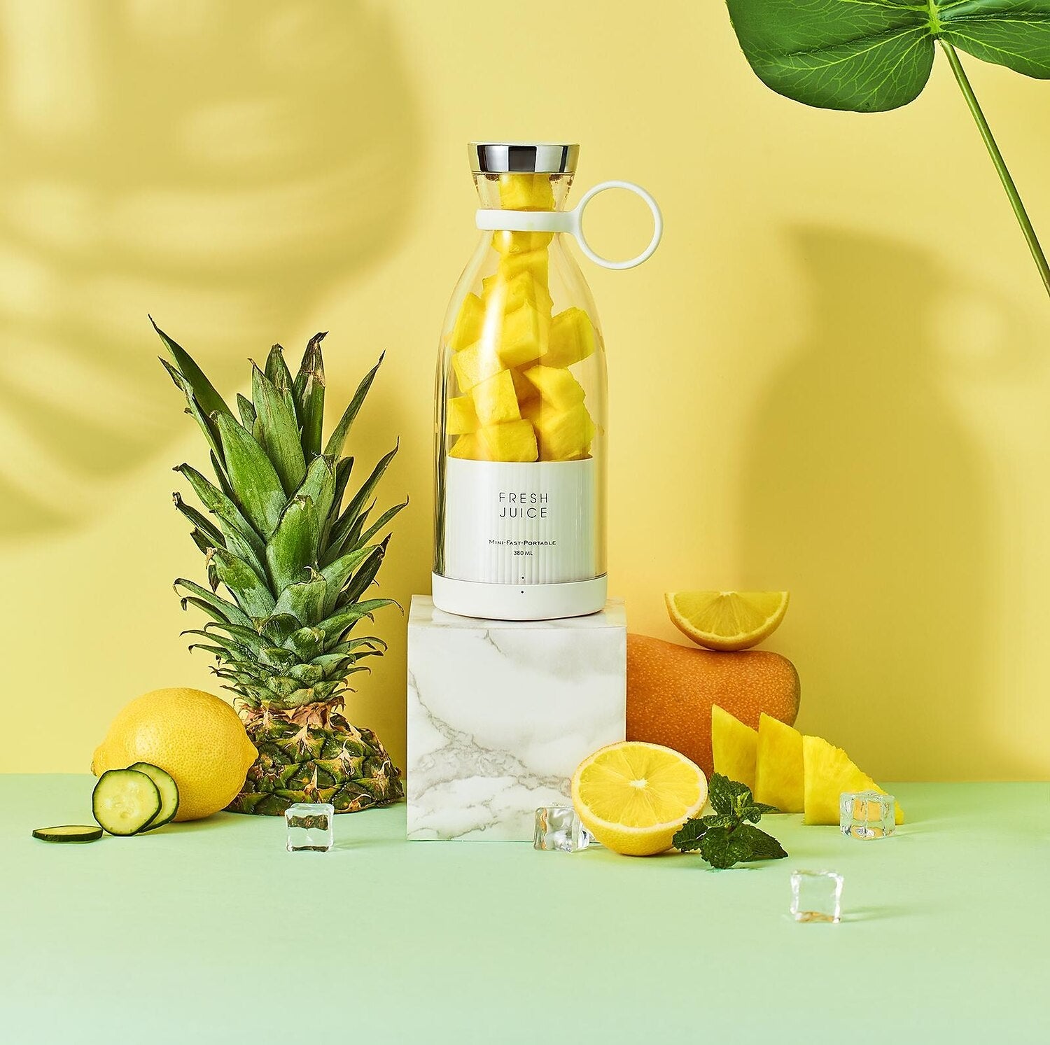 Bottle of 'Fresh Juice' with pineapple and lemon on a yellow background